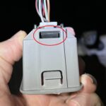 OBD2 port locking tabs location circled in red