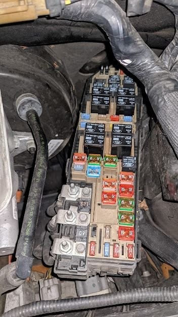 Fuse box of a 2009 Ford Hybrid Escape showing missing fuses, a potential issue for OBD2 system and starting problems.